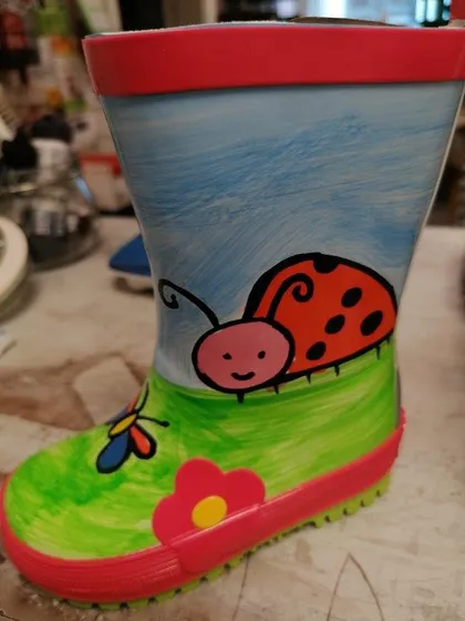 Grüner Gummistiefel mit Marienkäfer und Blumen