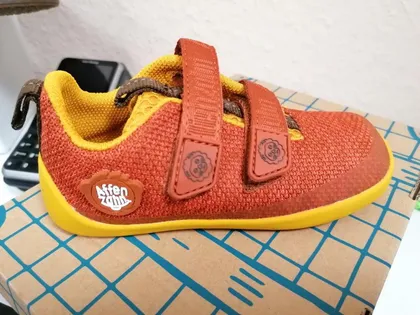 Orangefarbener Klettschuh mit gelber Sohle