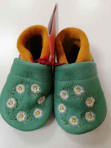 Grüner Krabbelschuh aus Leder mit Gänseblümchen