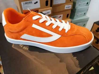 Orangefarbener Sneaker aus Wildleder mit weißen Streifen